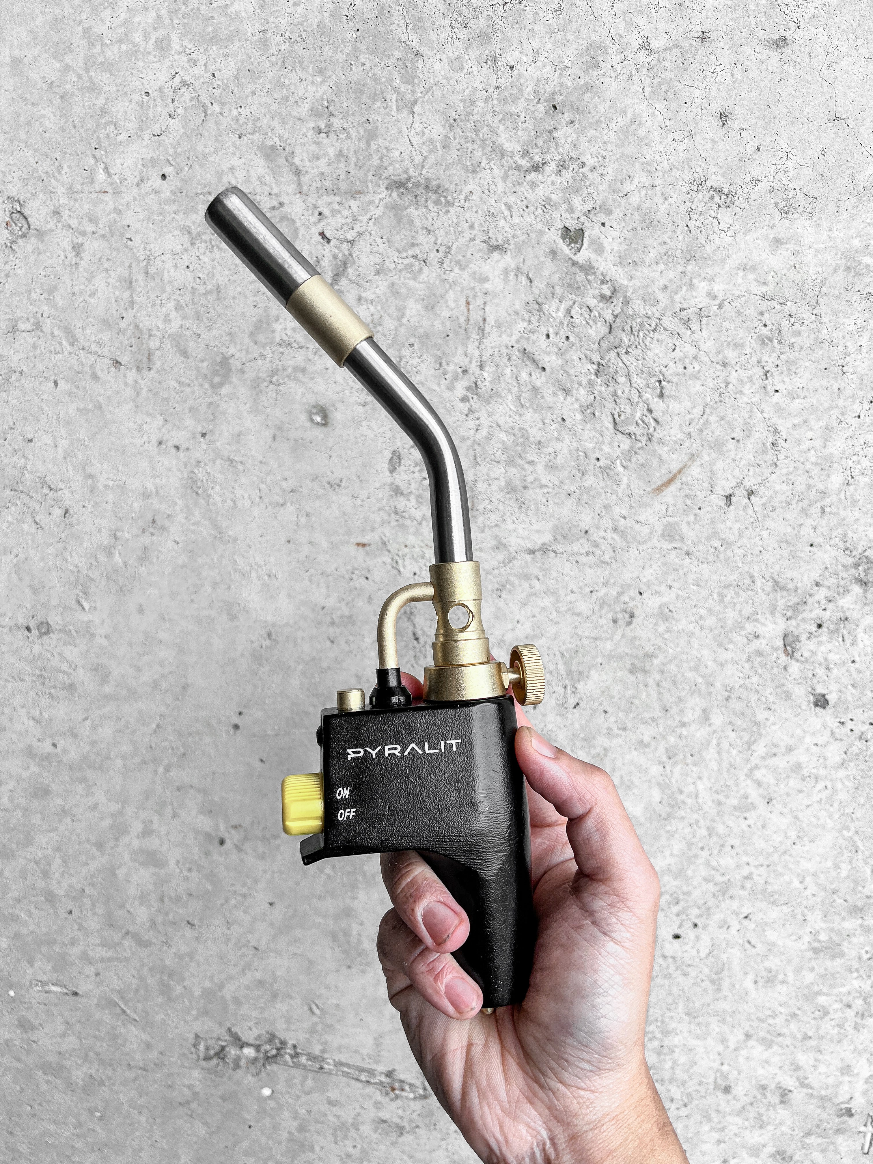 A person with their left arm across their stomach wearing a white sweatshirt featuring a groundhog drawing on the chest and leaves on the sleeves.