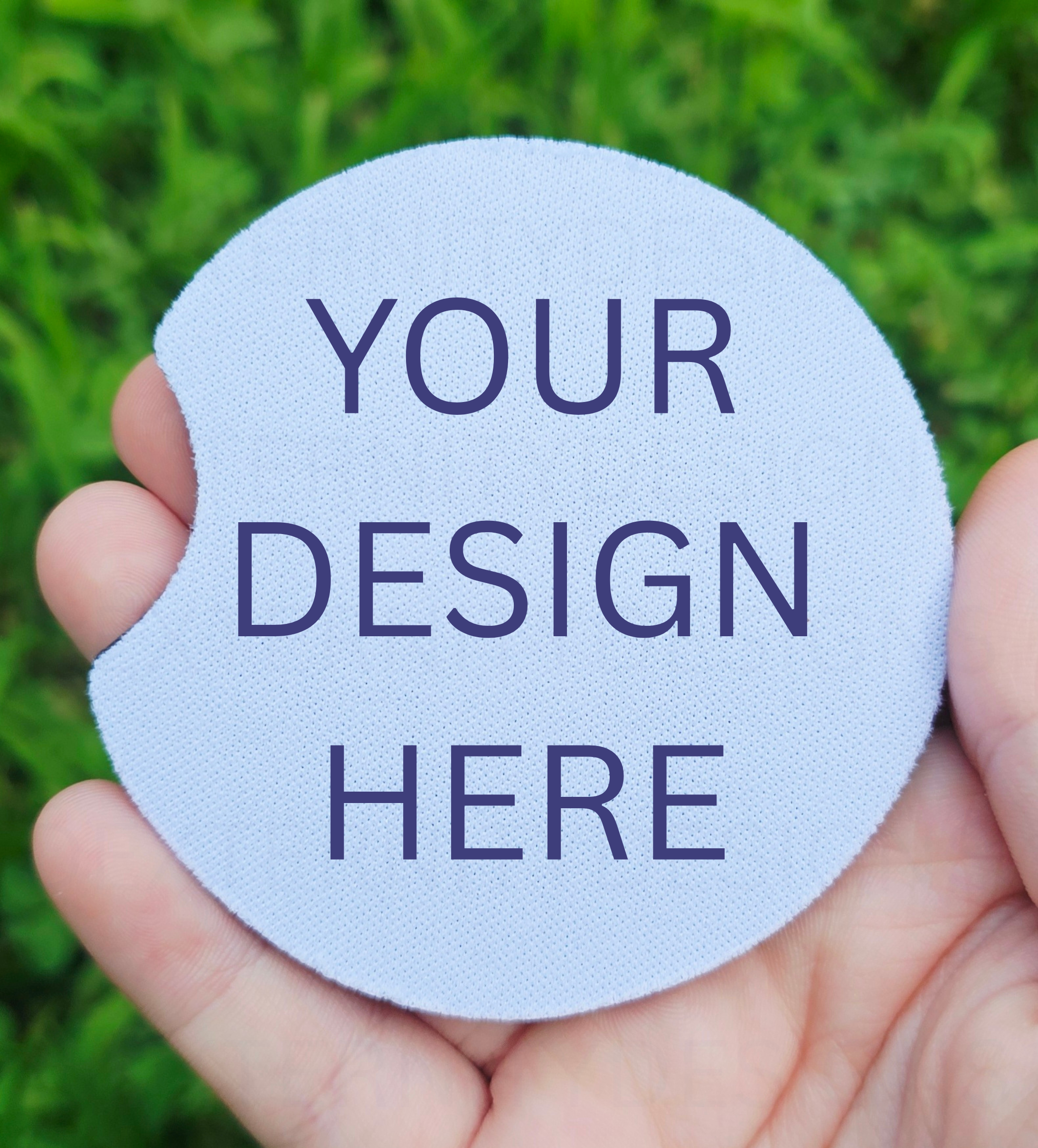 Hand holding a circular coaster designed for car cup holders with text that read "Your design here"